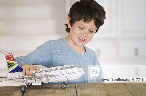 Little boy playing with model aeroplane