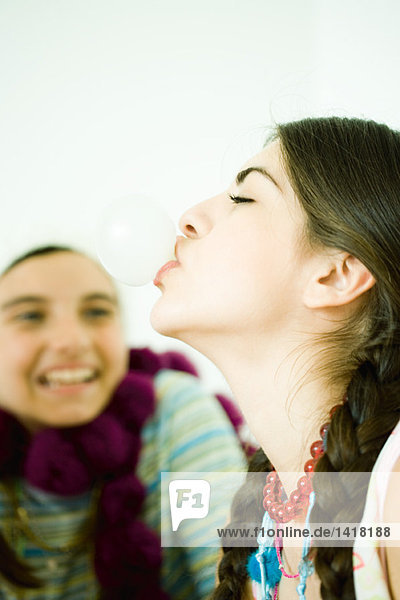 Zwei junge Freundinnen  eine Blasenblase mit Kaugummi