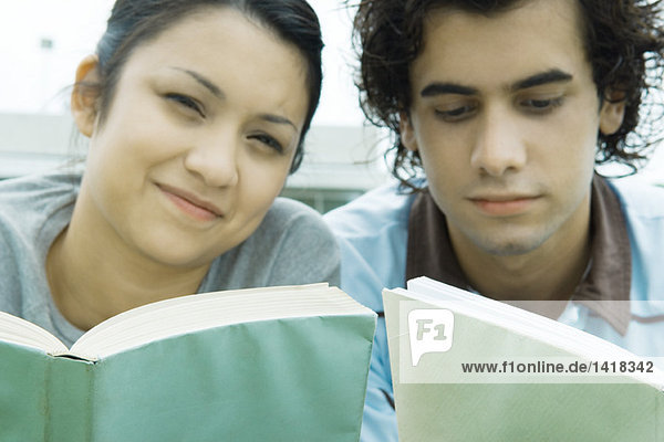 Junges erwachsenes Paar beim Lesen im Freien  Nahaufnahme