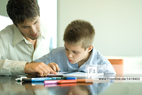Vater und Sohn machen gemeinsam Hausaufgaben