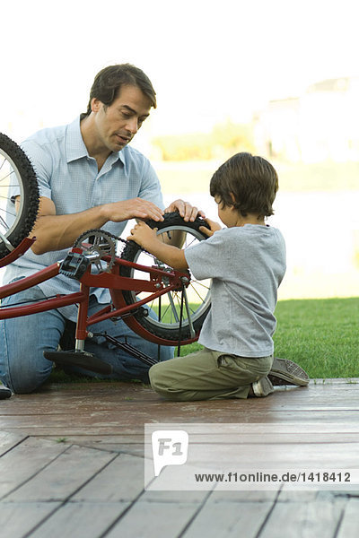 Vater und Sohn reparieren Fahrrad zusammen
