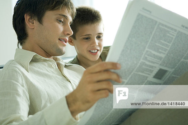 Vater und Sohn lesen gemeinsam Zeitung