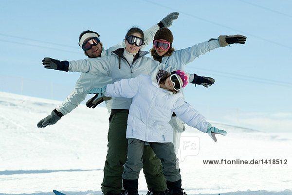 Junge Skifahrer auf der Piste mit ausgestreckten Armen  Ganzkörperporträt