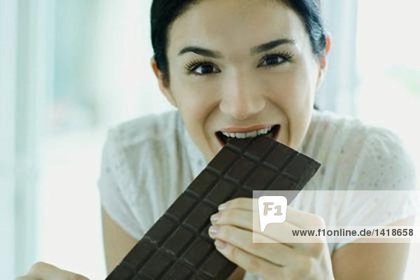 Frau isst große Tafel Schokolade
