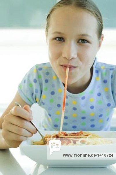 Mädchen schlürfen Spaghetti-Nudeln