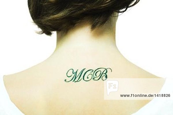 Teenage girl with initial's tattooed onto upper back  close-up