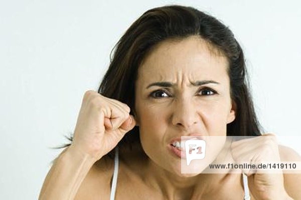 Frau macht wütendes Gesicht  hält die Fäuste hoch  Porträt