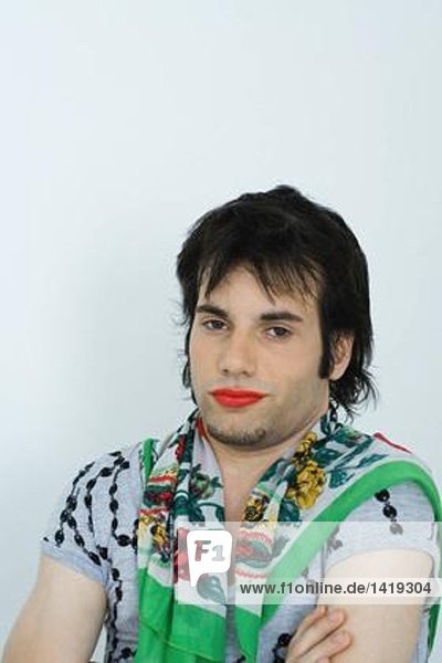 Junger Mann mit Lippenstift und Schal um den Hals  Porträt