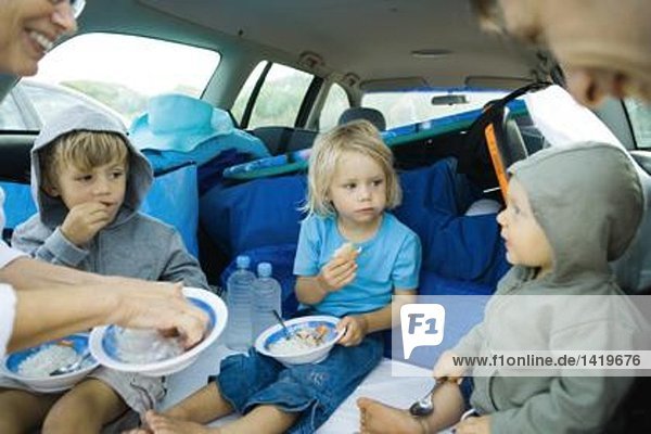 Kinder essen Essen hinten im Auto
