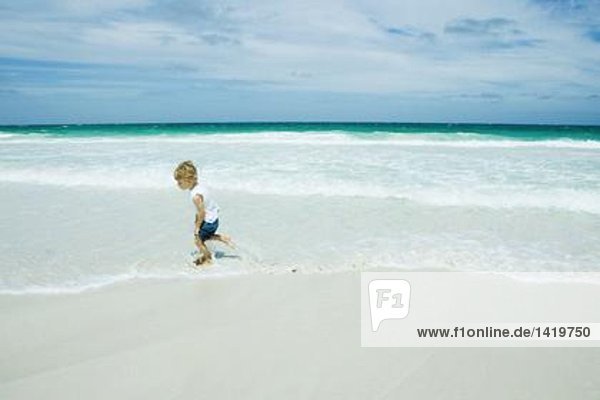 Kind beim Surfen am Strand
