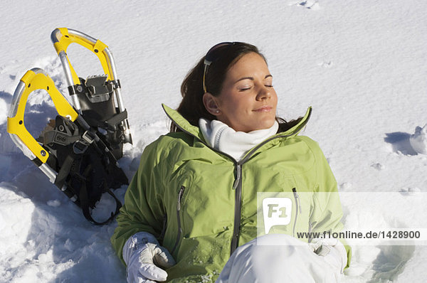 Frau mit Schneeschuhen  entspannend