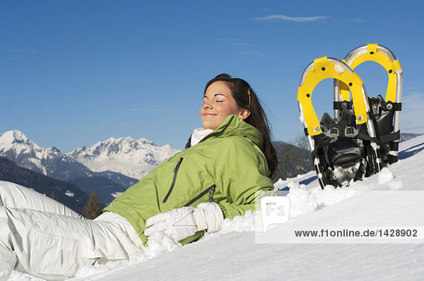 Frau mit Schneeschuhen  entspannend