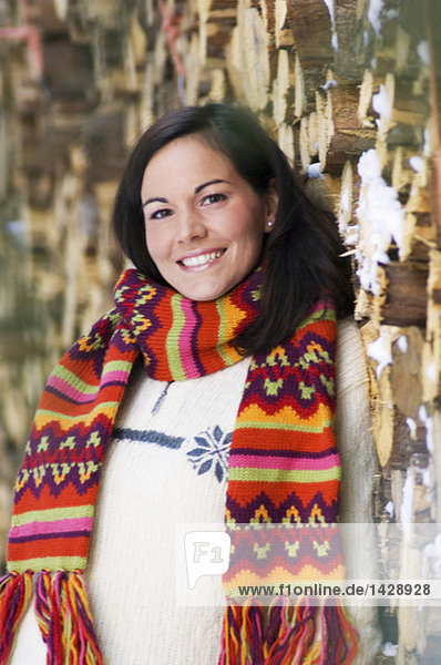 Woman leaning on stack of wood  portrait