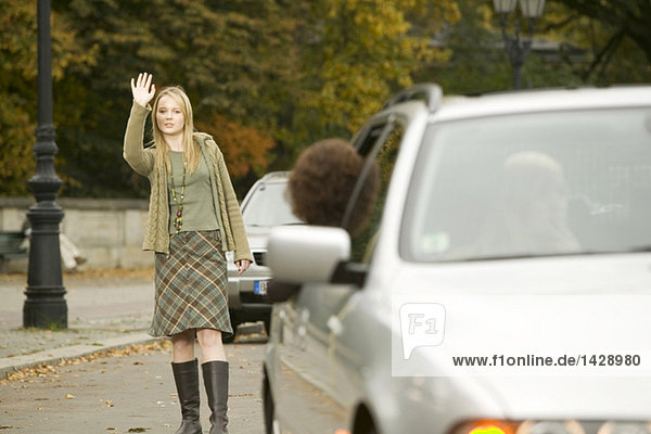 Girl standing in street,  waving hand