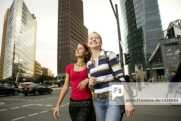 Two girl friends strolling in city