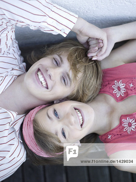 Young couple lying on floor  holding hands