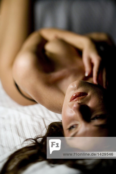 Naked woman lying in bed