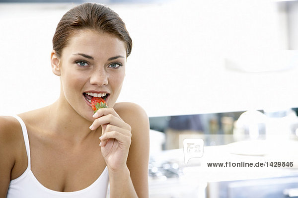 Young woman eatung strawberry