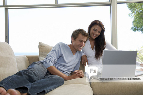 Paar auf der Couch sitzend  mit Laptop