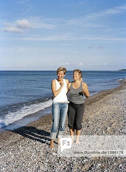 Zwei lachende Frauen am Strand.