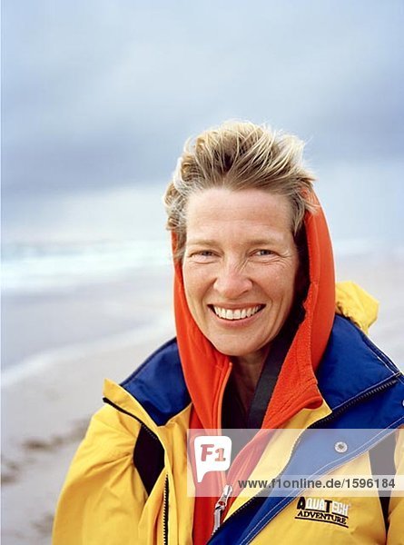 Porträt einer Frau an einem windigen Strand.