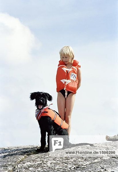 Girl and dog wearing life jackets.