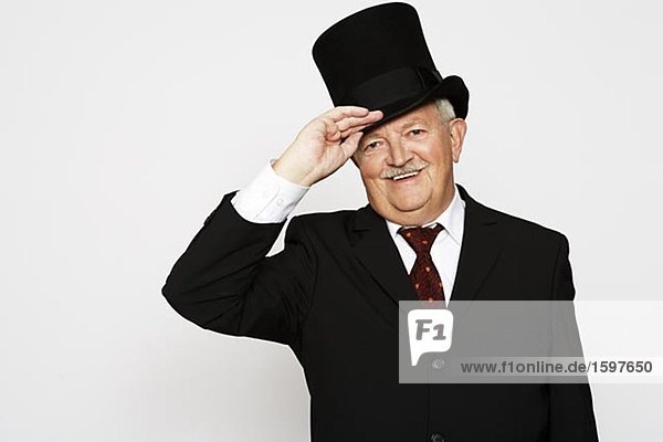 Ein lächelnd mann in einem Anzug und einen Hut.