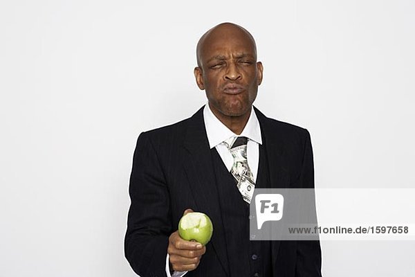 Ein Mann mittleren Alters ein Anzug einen Apfel Essen.
