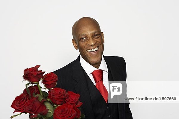 Ein Mann einen Anzug mit und ein paar rote Rosen