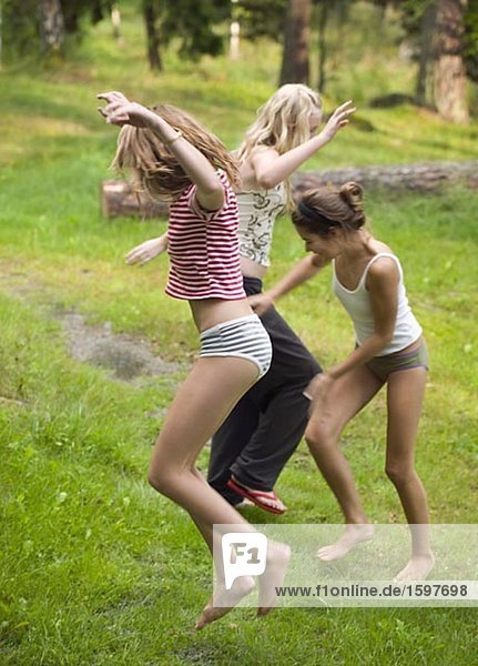 Three teenagers jumping around and dancing.