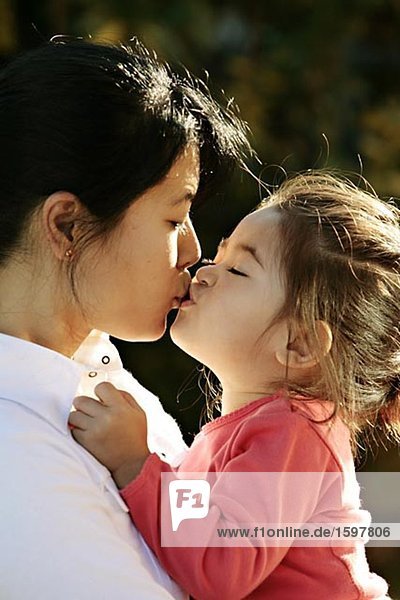 Eine Mutter ihre Tochter zu küssen.