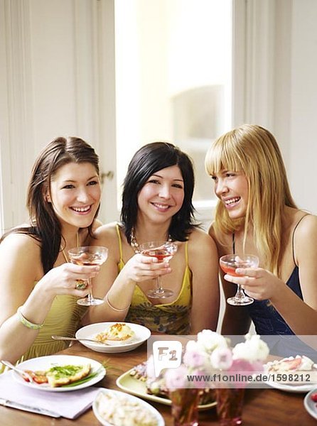 Three young smiling women during a dinner Sweden.