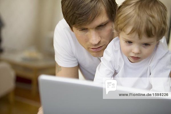 Father and a small child in front of a computer at home Sweden.