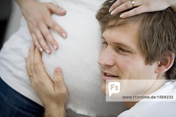 Ein Mann eine schwangere Frau Magen Schweden anhören.