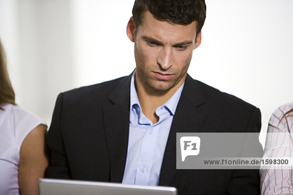 A man with a computer in an office.
