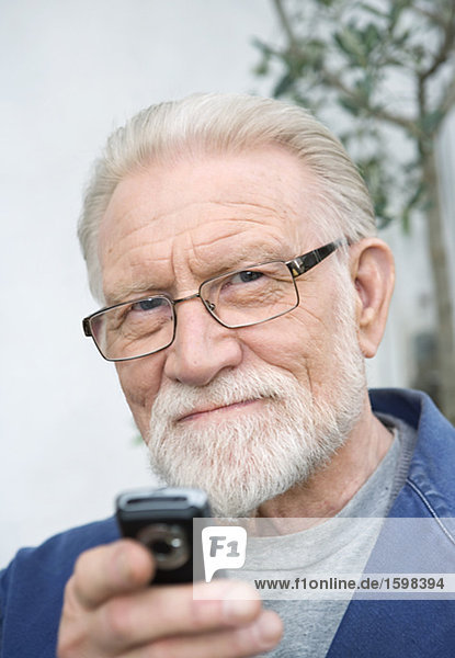 An elderly man using a cell phone.