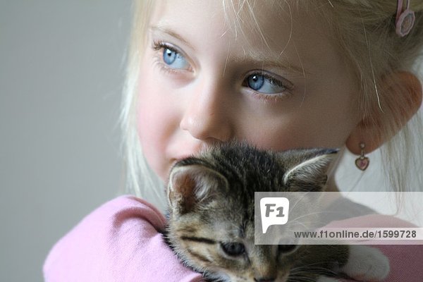 Close-up of girl holding kitten