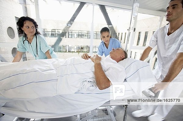 Krankenschwestern tragen Patienten