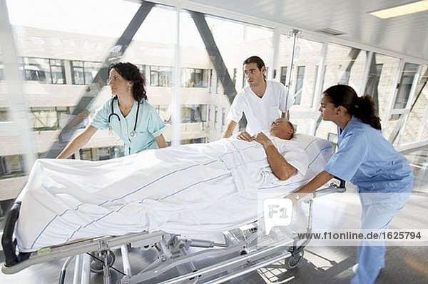 Krankenschwestern tragen Patienten