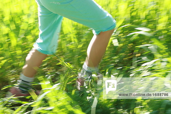 Low section view of child walking in field