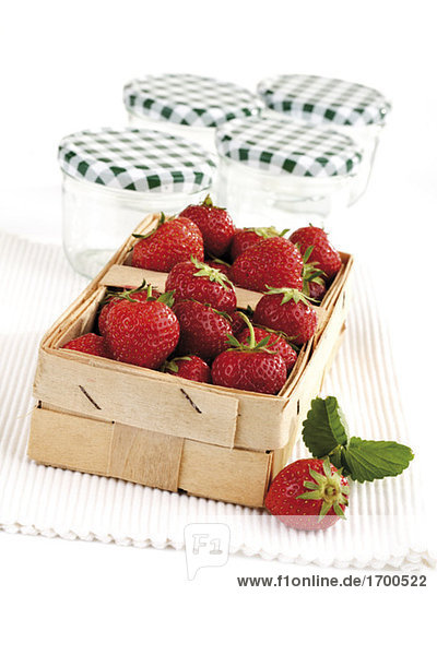 Erdbeeren im Korb und Gläser