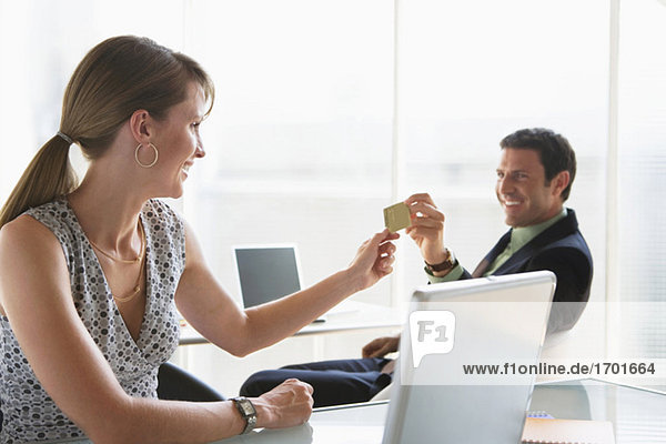 Boss handing credit card to collegue
