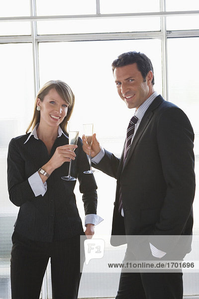 Business woman and man toasting with sparkling wine