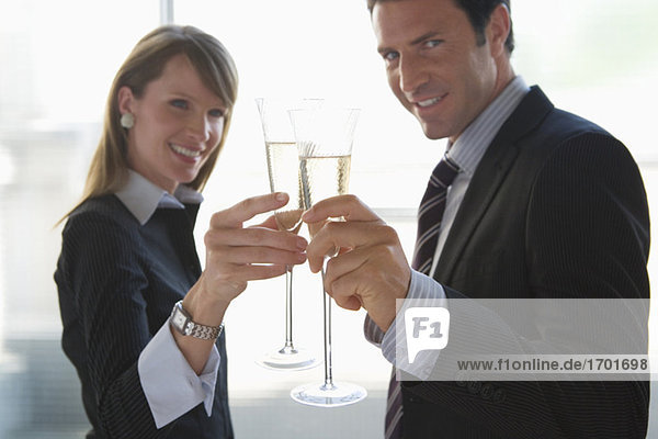 Business woman and business man toasting with sparkling wine