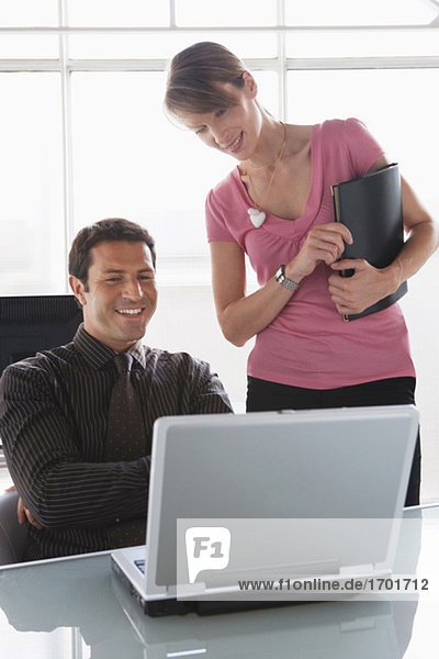 Business teamwork: man and woman working on laptop