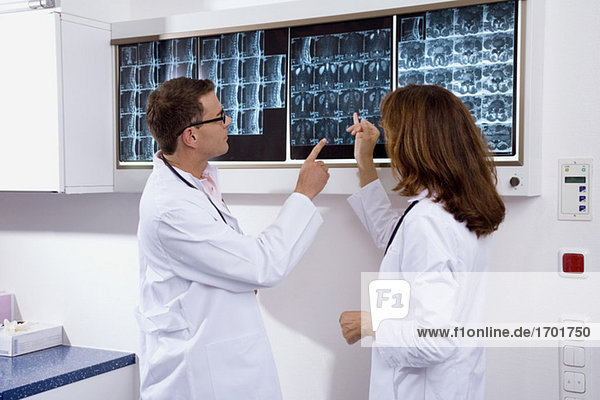 Arzt und Ärztin bei der Untersuchung eines Röntgenberichtes
