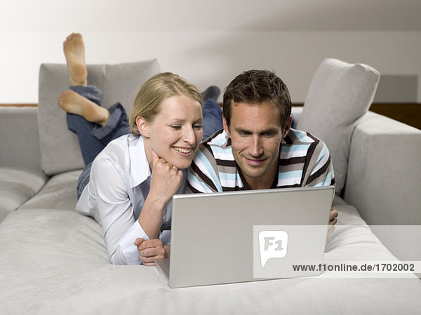 Paar auf Sofa  mit Laptop