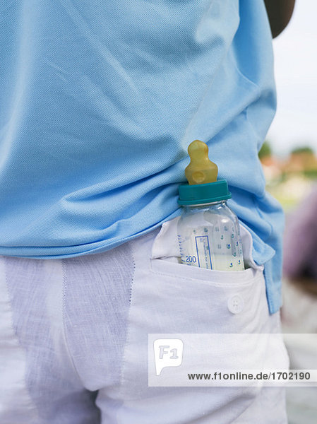 Mann mit Babyflasche in der Tasche  Rückansicht