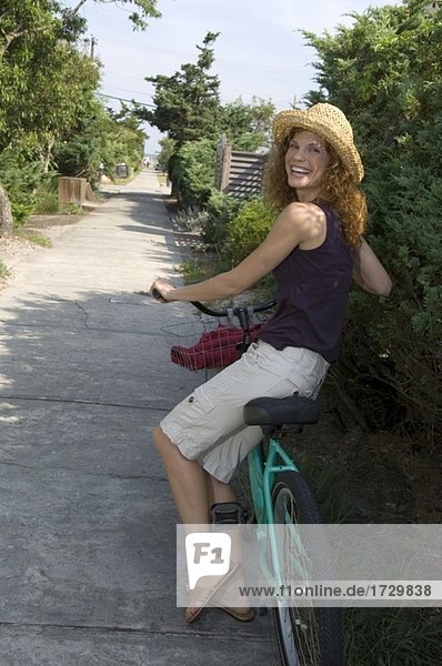 Frau zu Fuß mit Fahrrad und lächelnd Außenaufnahme