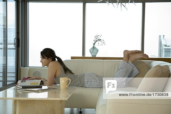 Junge Frau mit Laptop auf sofa